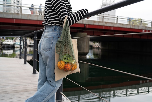 Donna vista laterale con borsa in tessuto