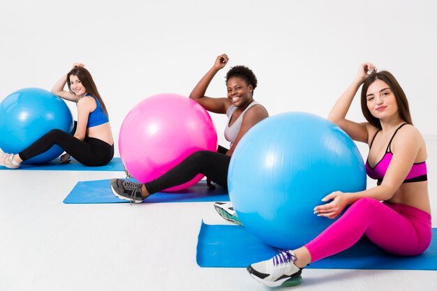 Donne a lezione di fitness lavorando sul tappetino