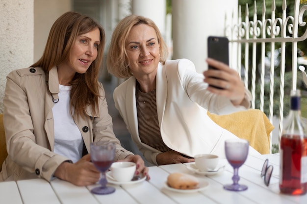 Donne a tiro medio che si fanno selfie