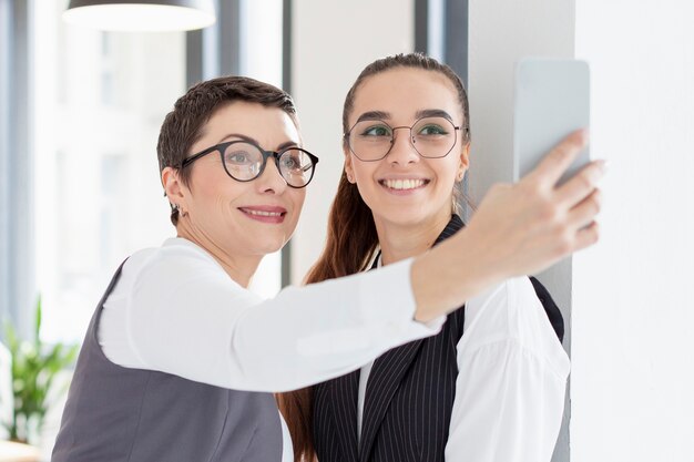 Donne adulte che prendono un selfie all'ufficio