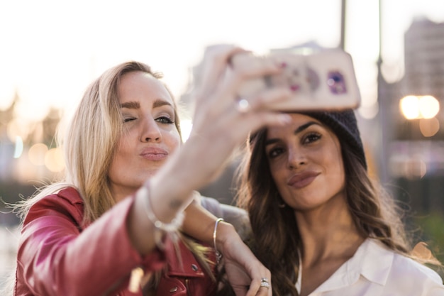 Donne alla moda che posano per selfie