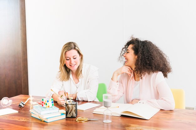 Donne allegre che studiano al tavolo