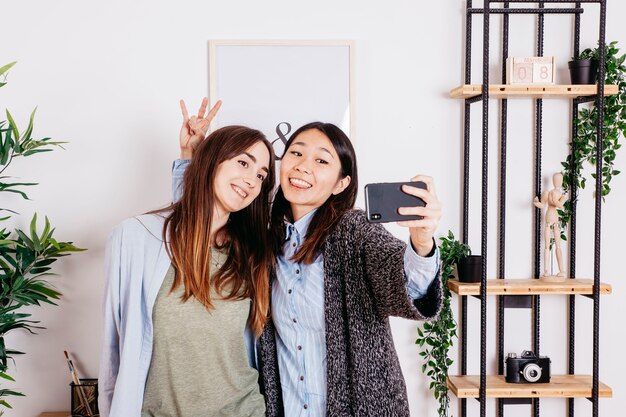 Donne amichevoli che posano per selfie