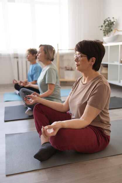 Donne anziane che fanno yoga e trascorrono del tempo insieme