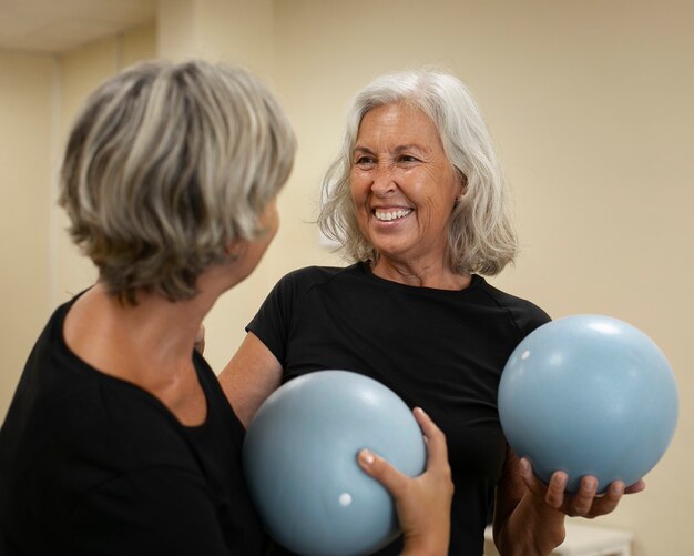 Donne anziane di livello medio in classe di riformatore di pilates