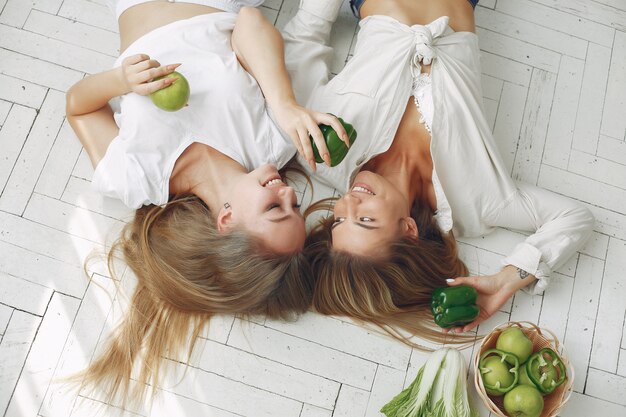 Donne belle e sportive in una cucina con verdure