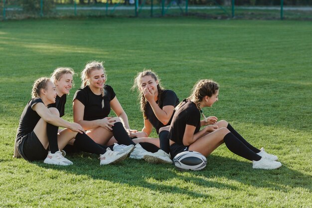 Donne bionde atletiche che si siedono sull'erba