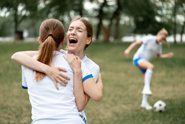 Donne che abbracciano sul campo di calcio