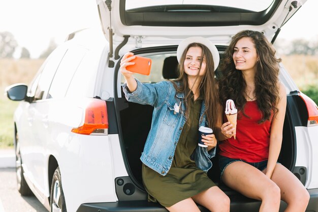 Donne che assumono selfie sul bagagliaio