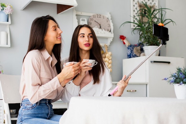 Donne che bevono caffè e prendono selfie