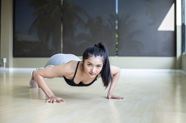 Donne che esercitano spingendo il pavimento in palestra