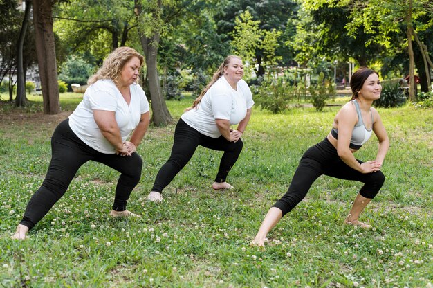 Donne che fanno affondi nella vista lunga del parco