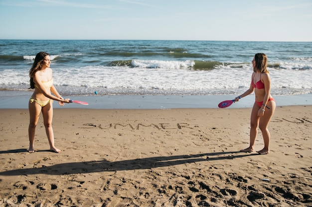 Donne che giocano a ping pong in spiaggia