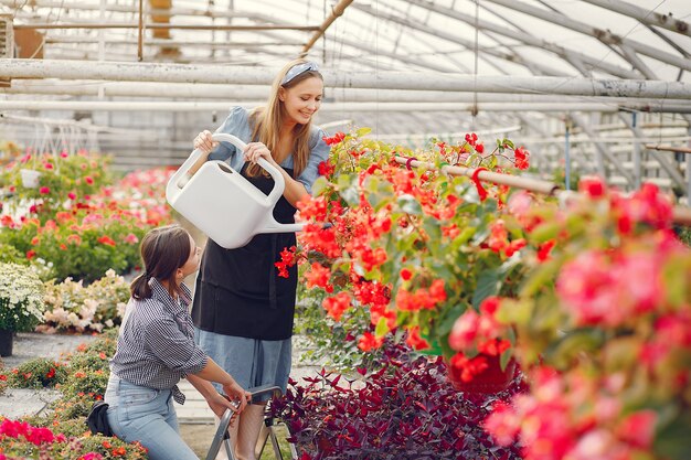 Donne che lavorano in una serra con vasi di fiori