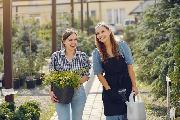 Donne che lavorano in una serra con vasi di fiori