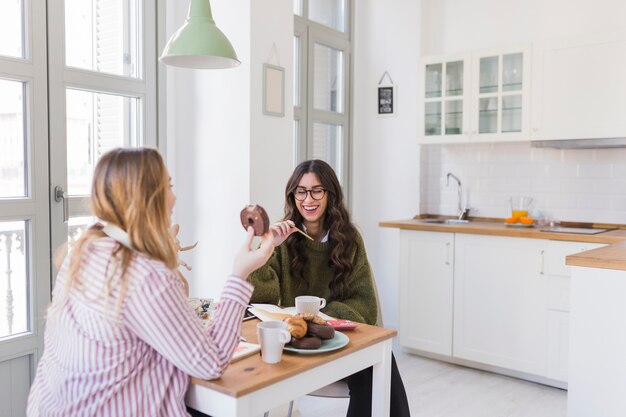 Donne che mangiano e disegnano in cucina