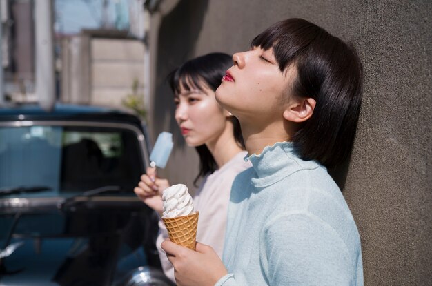 Donne che mangiano il gelato insieme vista laterale