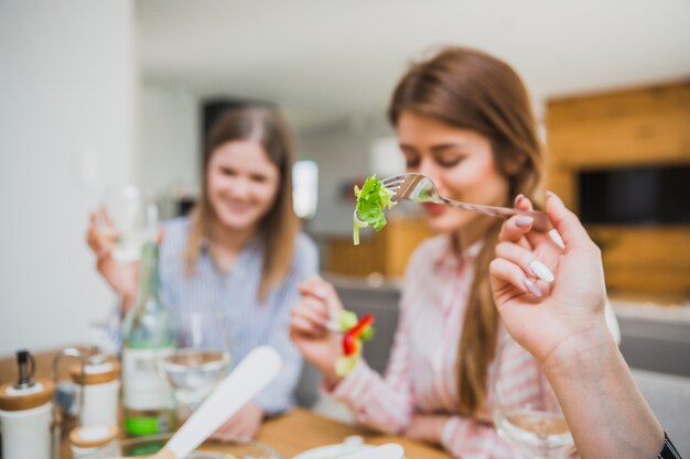 Donne che mangiano insalata in salotto