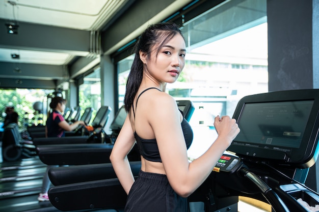 Donne che pareggiano sul tapis roulant in palestra