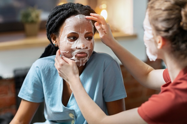 Donne che praticano la cura della pelle a casa