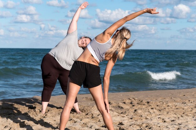 Donne che si allenano insieme sulla spiaggia