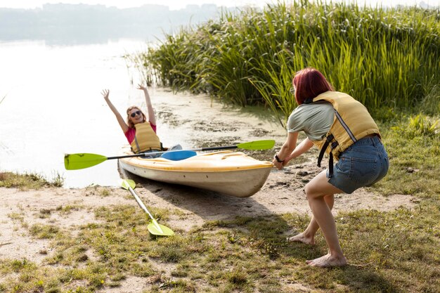 Donne che spingono l'acqua di introduzione del kayak