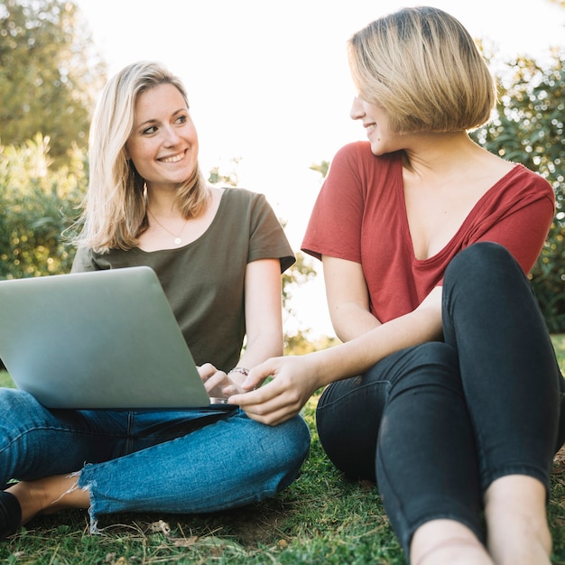 Donne con il computer portatile a guardare l&#39;un l&#39;altro