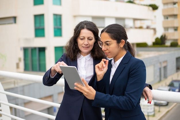 Donne d'affari contente che utilizzano tablet pc