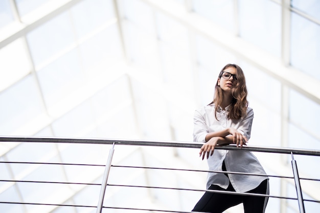 Donne d'affari di successo in piedi guardando attraverso il balcone nel centro ufficio moderno vestite in maglietta bianca