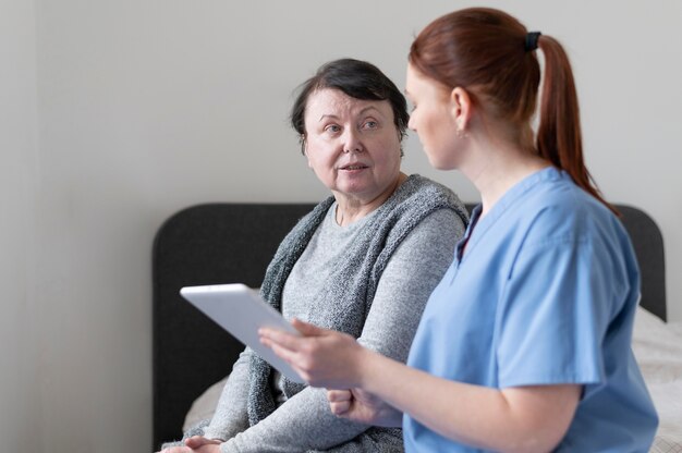 Donne del colpo medio sedute con tablet