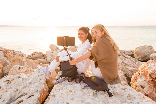 Donne del colpo pieno che prendono insieme i selfie