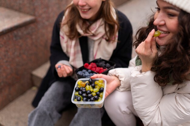 Donne dell'angolo alto che mangiano bacche