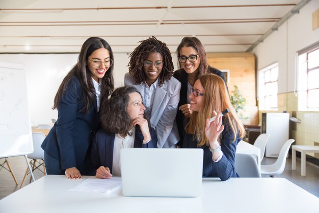 Donne di affari contente che lavorano con il computer portatile