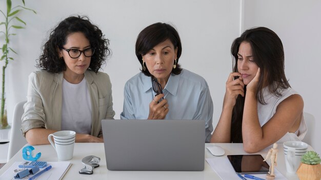 Donne di affari di vista frontale che lavorano ad un computer portatile