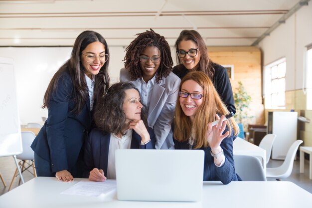 Donne di affari felici che lavorano con il computer portatile