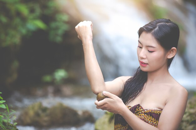 Donne di balneazione felici alla cascata naturale