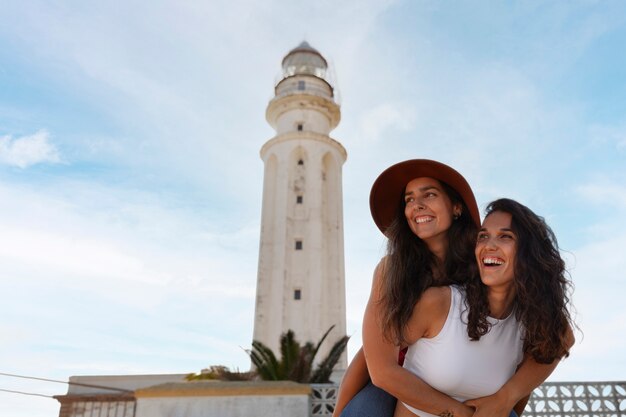 Donne di media foto che posano con il faro