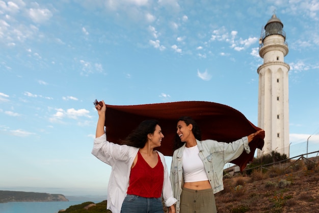 Donne di media foto che posano con il faro