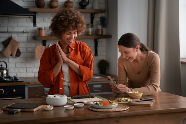 Donne di medio livello che imparano a preparare il sushi