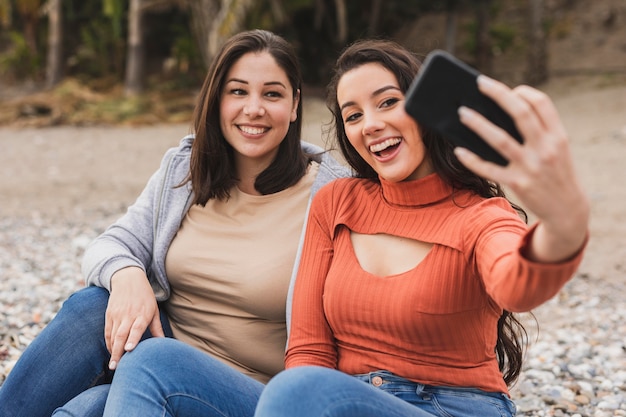 Donne di smiley che prendono selfie