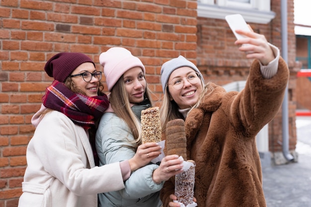 Donne di smiley colpo medio che prendono selfie