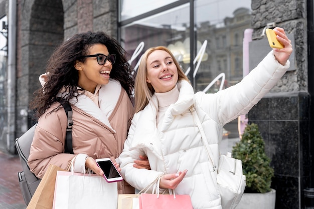 Donne di smiley colpo medio che prendono selfie