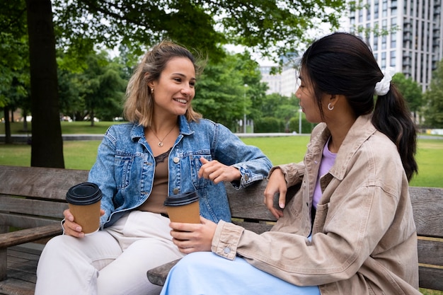 Donne di smiley colpo medio con tazze di caffè