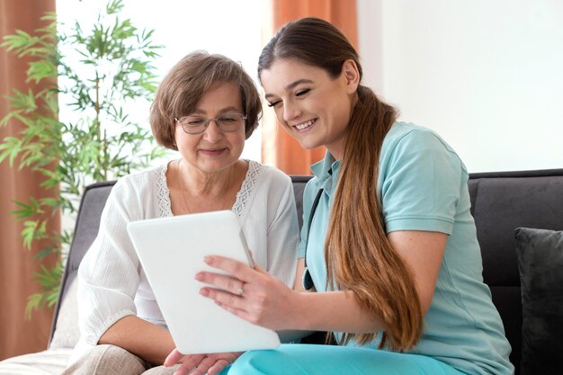 Donne di smiley del colpo medio che esaminano la compressa