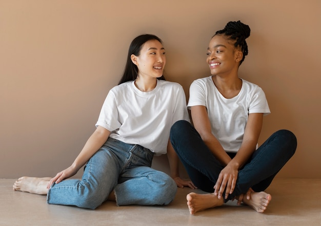 Donne di smiley del colpo pieno che si siedono sul pavimento