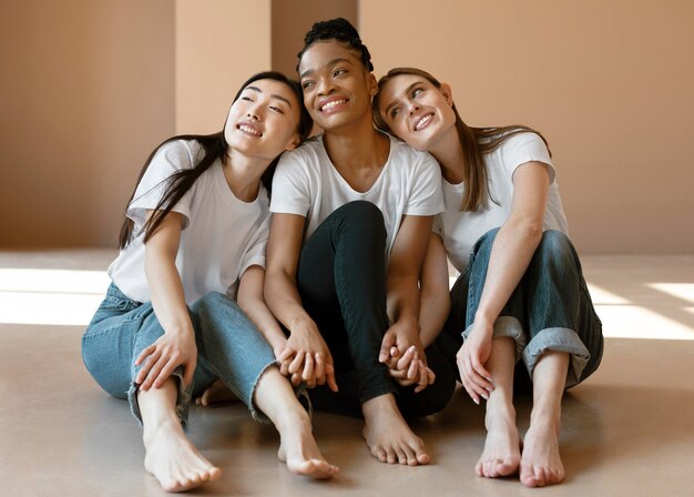 Donne di smiley del colpo pieno che si siedono sul pavimento