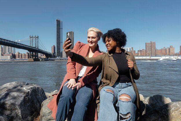 Donne di tiro medio che prendono selfie a new york