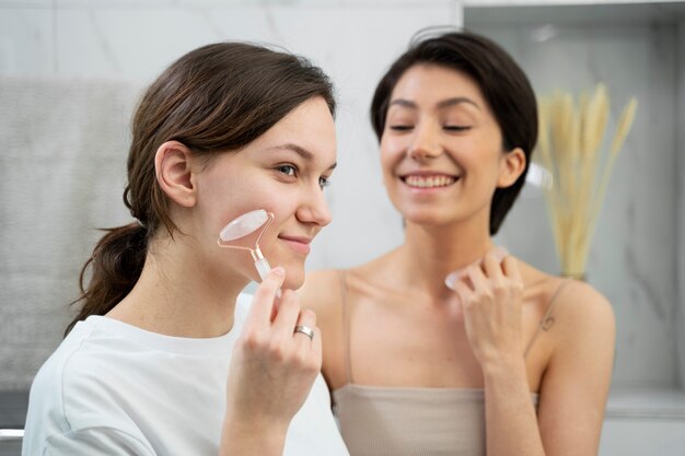 Donne di tiro medio che tengono strumenti di gua sha