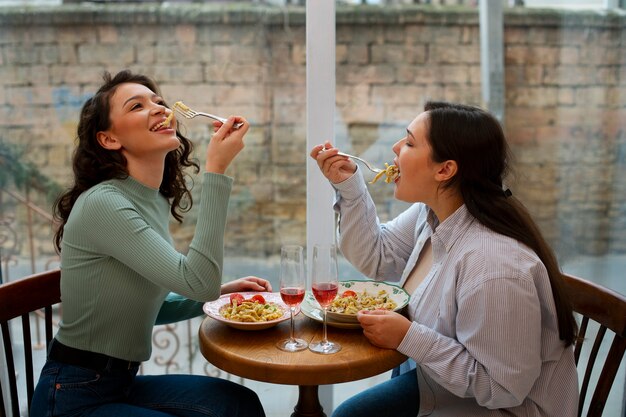 Donne di tiro medio con cibo delizioso