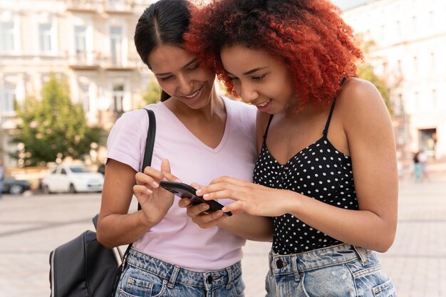 Donne di tiro medio con il telefono